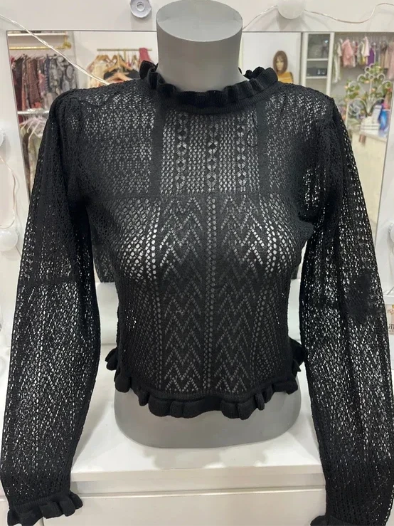 Top de punto calado negro con cuello alto y volantes