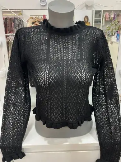 Top de punto calado negro con cuello alto y volantes