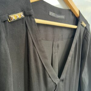 Blusa negra fluida con detalles metálicos